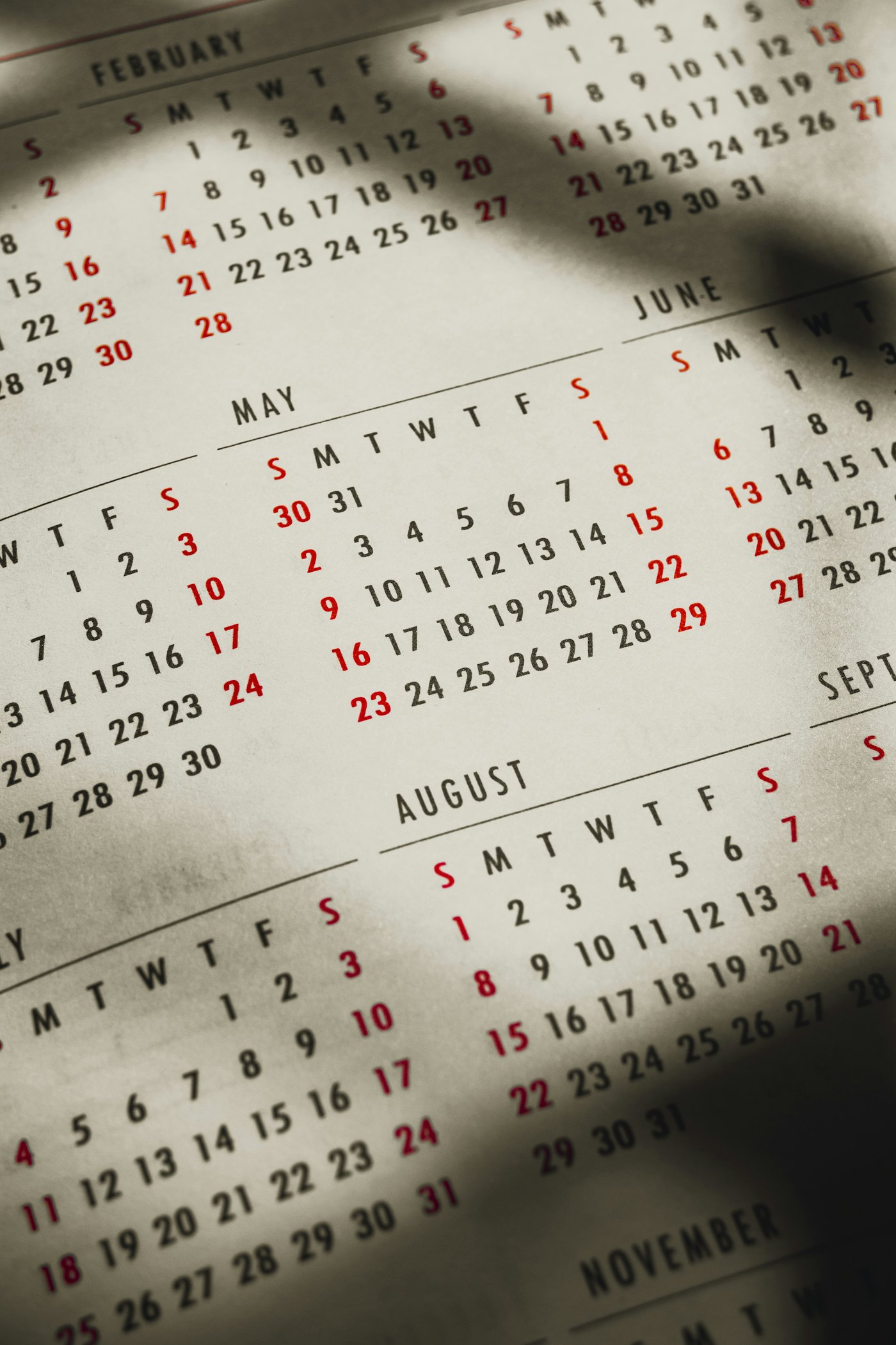 Overlapping wall calendar pages showing months layered across each other in soft light